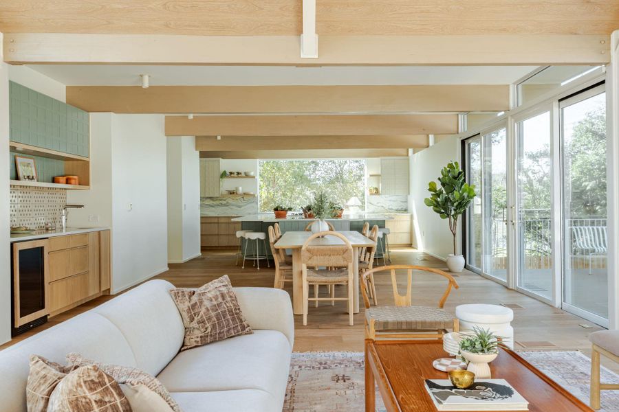 Living room with wine cooler, light wood-style floors, and beam ceiling