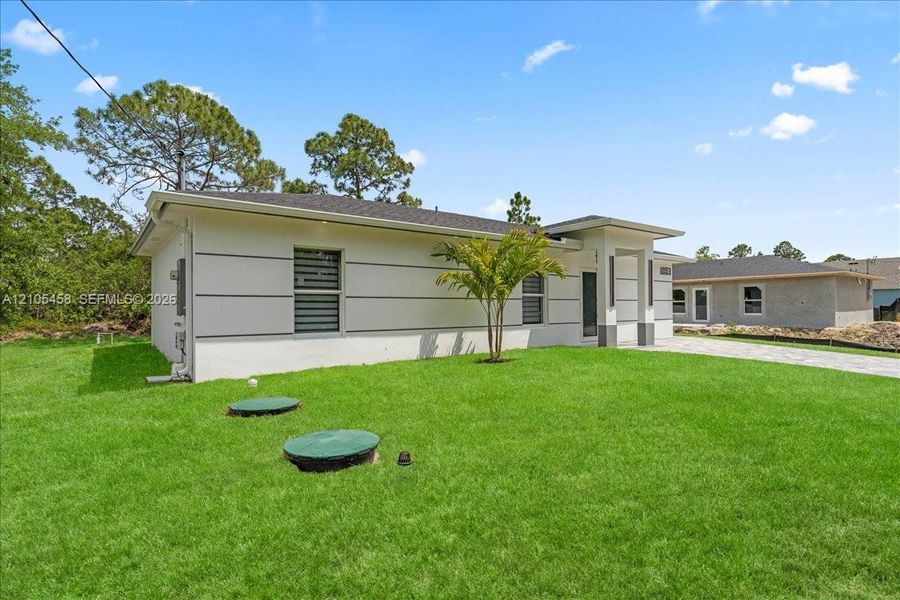 Modern exterior with white siding, dark gray accents, and a covered entry Modern exterior with white siding, dark gray accents, and a covered entry