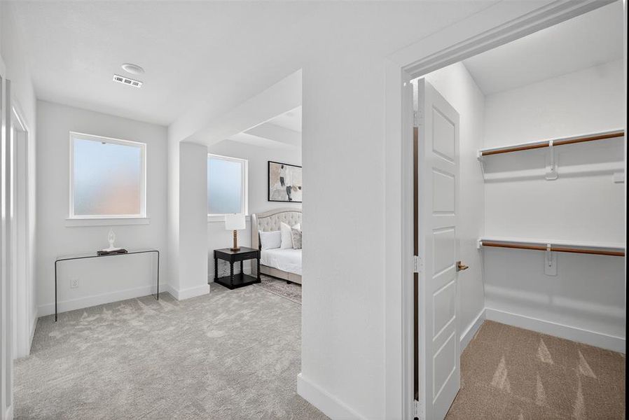 Hallway featuring light carpet and baseboards