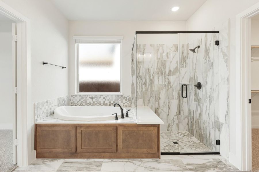 Master bathroom with soaking tub, wood surround, and glass-enclosed marble tile shower
