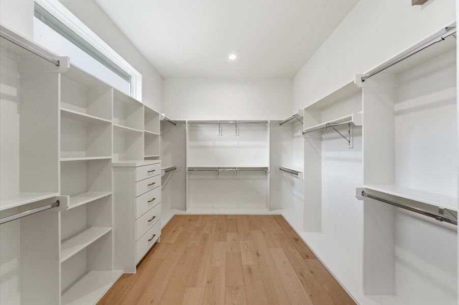 Oversized primary closet with a built in dresser.