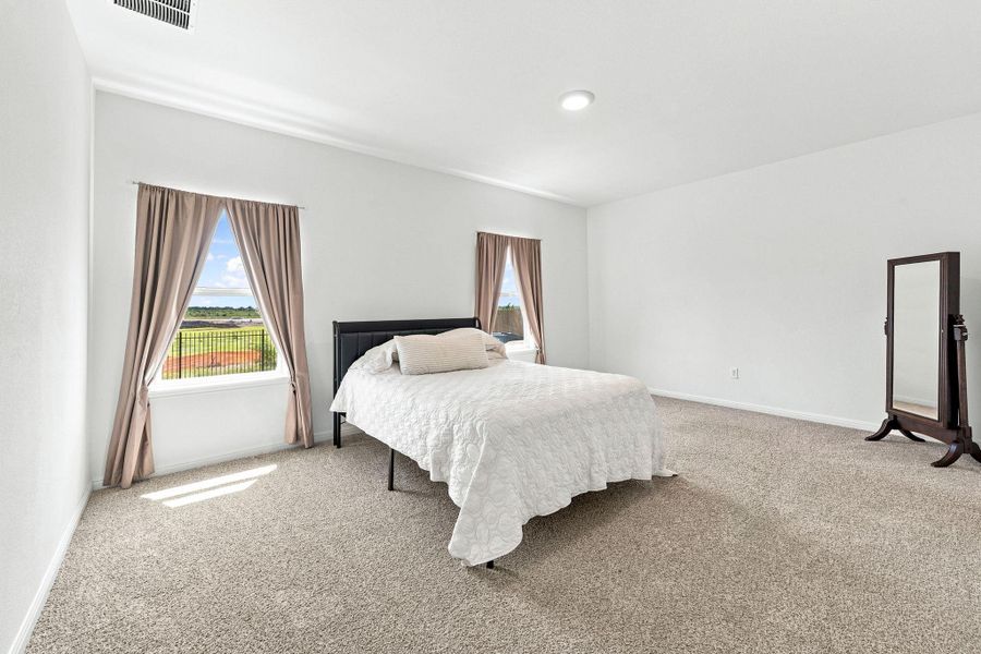 Plush carpeting and dual windows overlooking the outdoors anchor this comfortable sleeping space.