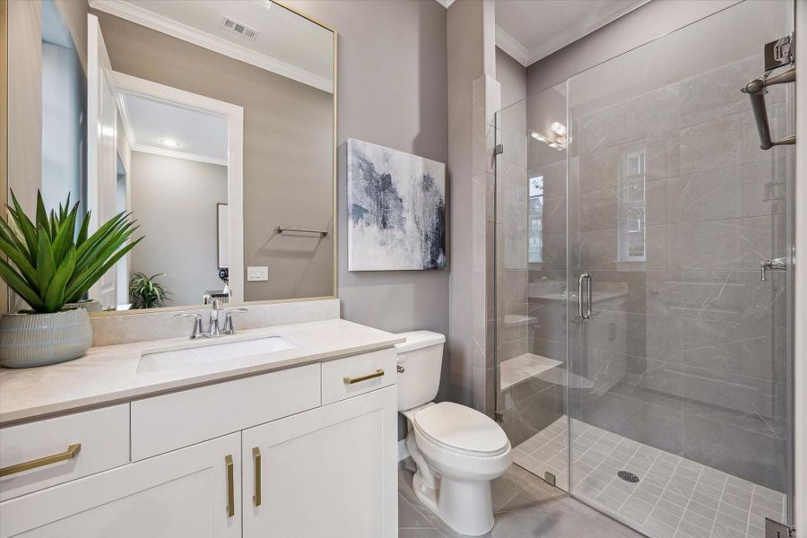 En-suite bath #2 - offers limestone countertop, shower/tub combo, built-in linen cabint, and goldframeless mirror.