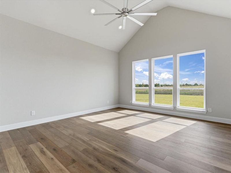 Spare room with high vaulted ceiling, wood finished floors, and ceiling fan Spare room with high vaulted ceiling, wood finished floors, and ceiling fan