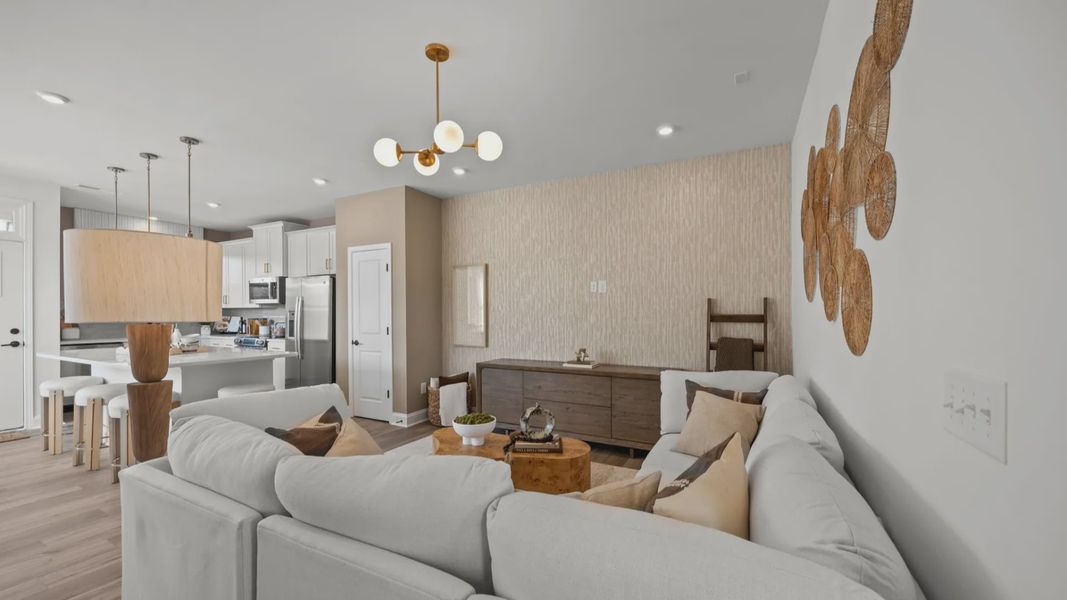 The Rochester Plan by DRB homes living area and kitchen featuring gold modern light fixtures in Charlotte, NC.