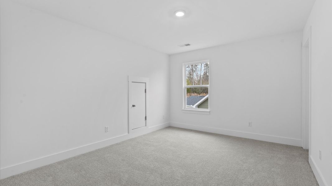 Accomplished design in this restful bedroom featuring plush carpet and oversized window views in Moore, SC