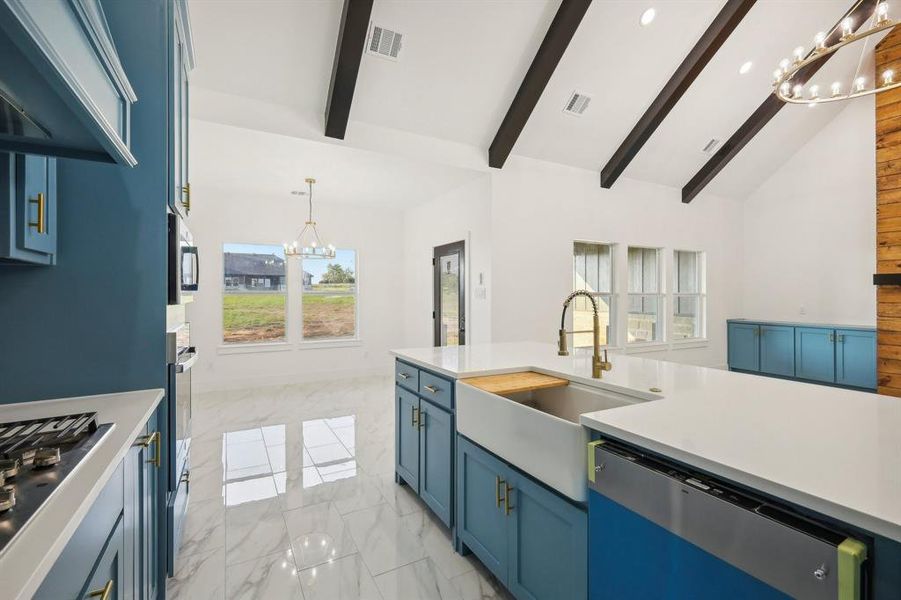 Kitchen featuring sink, hanging light fixtures, stainless steel appliances, an inviting chandelier, and blue cabinets