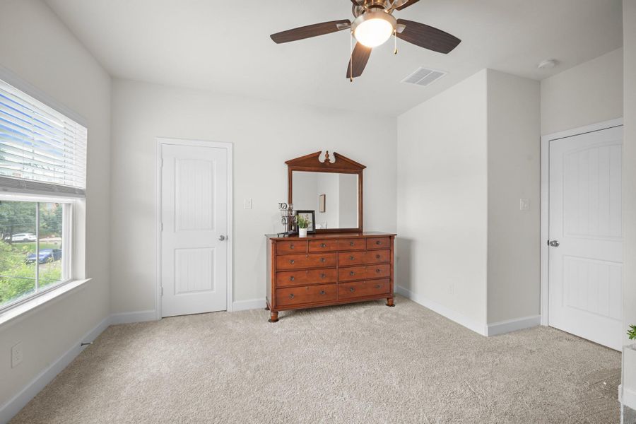 Another angle on this secondary bedroom captures the corner window light and the entry to a large walk-in closet — more storage than you'd expect. Another angle on this secondary bedroom captures the corner window light and the entry to a large walk-in closet — more storage than you'd expect.