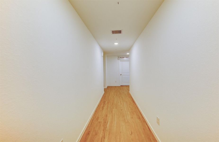 As you enter the home, you have a long hallway to personalize and customize as you and your guests enter. Just off to the left at the end of the hall is a doorway leading to the secondary bedooms and bathroom.