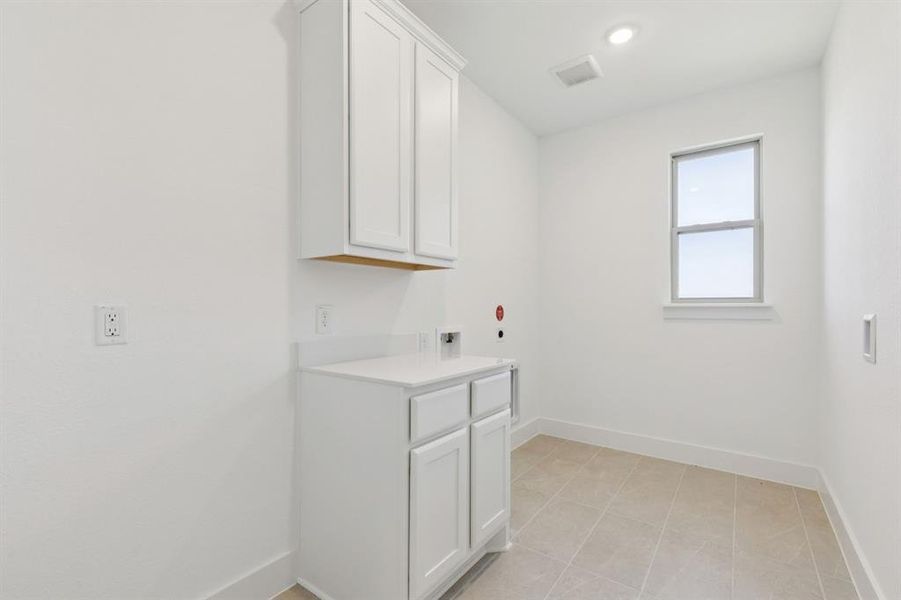 Laundry room with washer hookup, light tile patterned flooring, cabinet space, electric dryer hookup, and recessed lighting