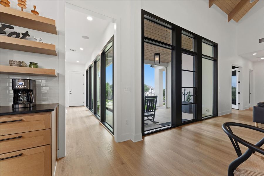 Open concept interior featuring wide plank wood-finish flooring and a high vaulted ceiling with wood paneling Open concept interior featuring wide plank wood-finish flooring and a high vaulted ceiling with wood paneling