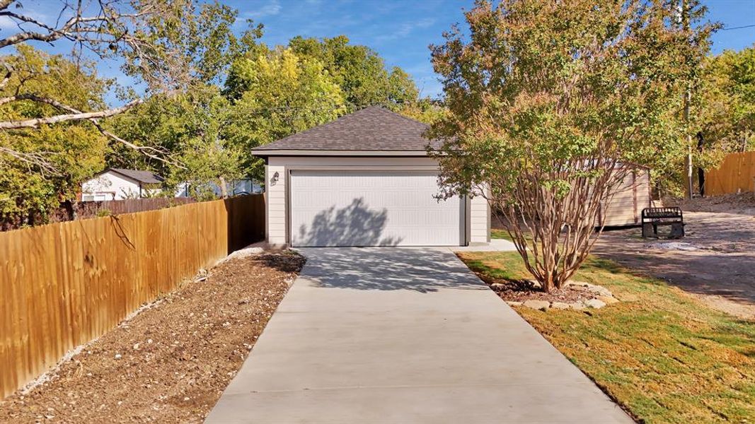 View of front of house featuring a garage and an outdoor structure