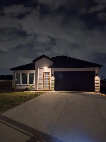 View of front of house with a front yard and a garage