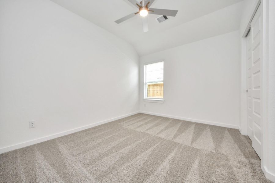 Secondary bedroom features plush carpeting, large windows that let in plenty of natural light, bright paint, and spacious closets.