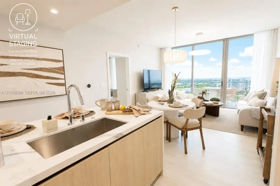 Open-concept kitchen featuring an integrated stainless steel basin sink, stone-surface countertop, and wood-finish cabinetry