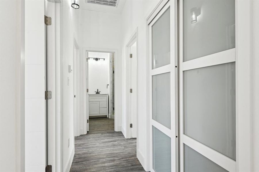 Corridor with dark wood-type flooring and baseboards Corridor with dark wood-type flooring and baseboards