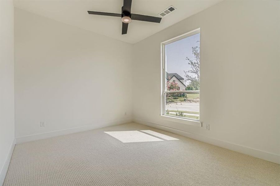Carpeted empty room featuring baseboards and a ceiling fan Carpeted empty room featuring baseboards and a ceiling fan