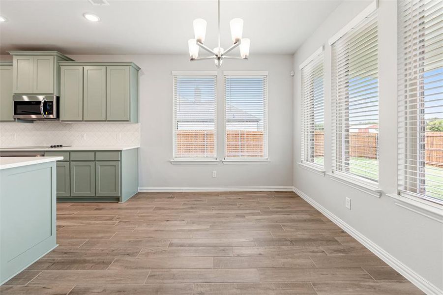 Unfurnished dining area with a chandelier, healthy amount of natural light, wood tiled floors, and recessed lighting Unfurnished dining area with a chandelier, healthy amount of natural light, wood tiled floors, and recessed lighting