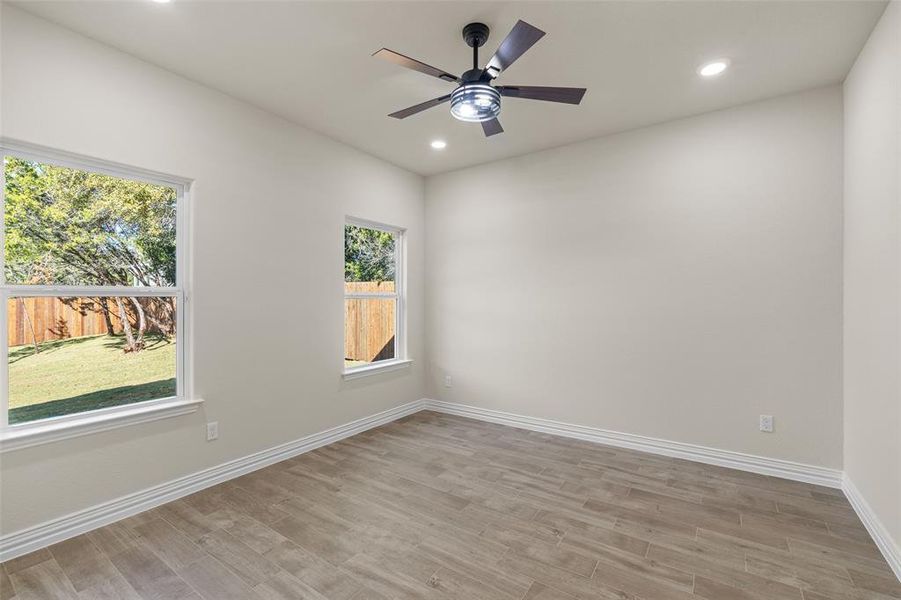 Empty room with ceiling fan and light wood-type flooring