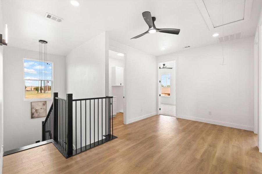 Unfurnished room featuring attic access, light wood finished floors, recessed lighting, and a ceiling fan Unfurnished room featuring attic access, light wood finished floors, recessed lighting, and a ceiling fan