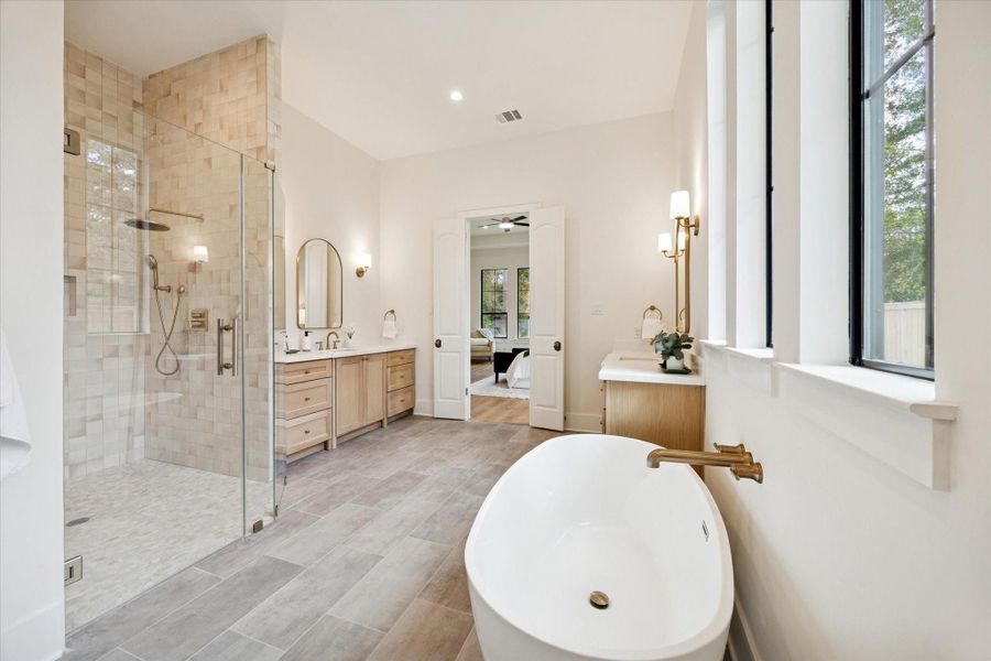 Primary bath with soaking tub, frameless glass shower, dual vanities, and clean modern finishes.