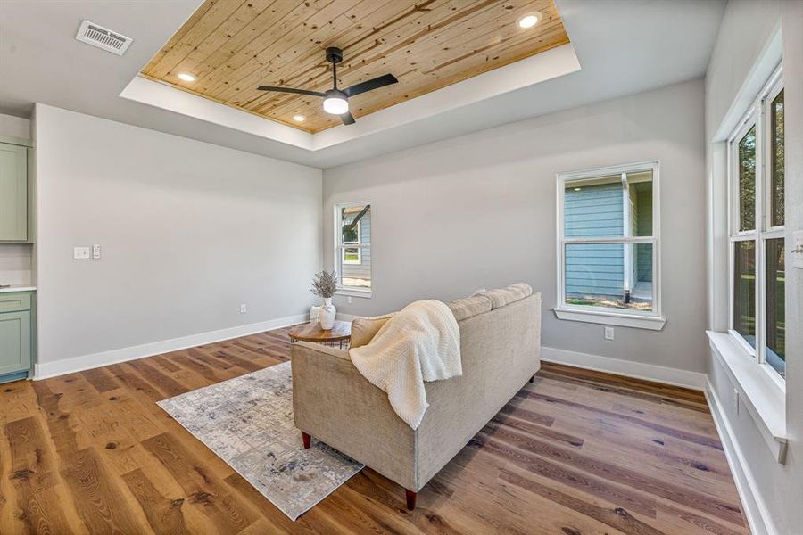 Living area featuring wood ceiling, a raised ceiling, recessed lighting, light wood-style flooring, and ceiling fan Living area featuring wood ceiling, a raised ceiling, recessed lighting, light wood-style flooring, and ceiling fan