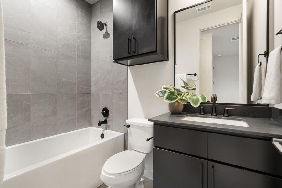 A well-appointed bathroom features a sleek vanity with a modern sink and a tub-shower combination. A well-appointed bathroom features a sleek vanity with a modern sink and a tub-shower combination.