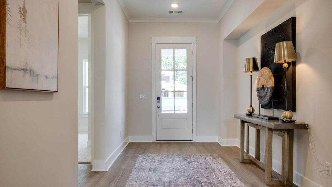 Front door leading into hallway with hard surface flooring