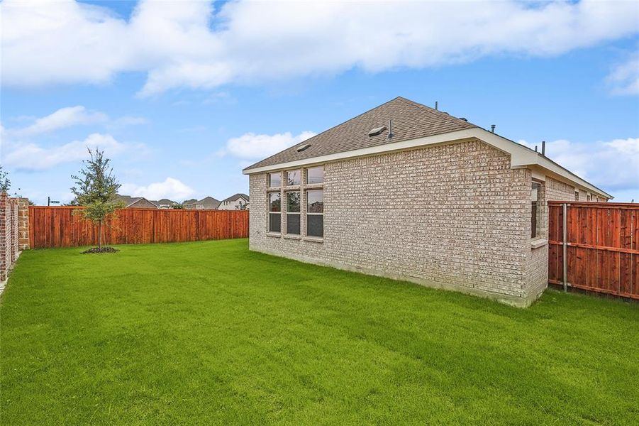 Rear view of house featuring a lawn