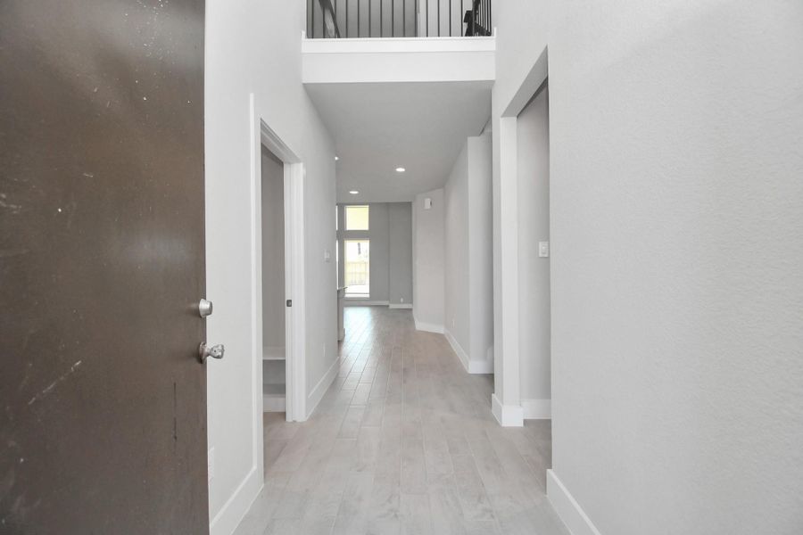 As you step into the threshold of this luxurious home, you'll soon be welcomed by an elegant glass door (to be installed). Inside, soaring ceilings amplify the spaciousness, while the refined wood-look tile flooring and oversized baseboards exude sophistication and charm. Sample photo of completed home with similar floor plan. Actual colors and selections may vary. As you step into the threshold of this luxurious home, you'll soon be welcomed by an elegant glass door (to be installed). Inside, soaring ceilings amplify the spaciousness, while the refined wood-look tile flooring and oversized baseboards exude sophistication and charm. Sample photo of completed home with similar floor plan. Actual colors and selections may vary.