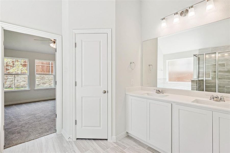 Bathroom with tile patterned flooring, ceiling fan, and dual bowl vanity