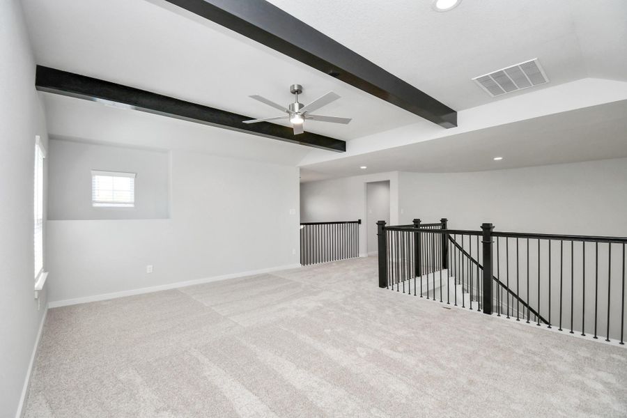 Come upstairs and enjoy a day of leisure in this fabulous game room! This is the perfect hangout spot or adult game room! Features plush carpet, high ceilings, custom paint and windows for plenty of natural light. Sample photo of completed home with similar floor plan. Actual colors and selections may vary.