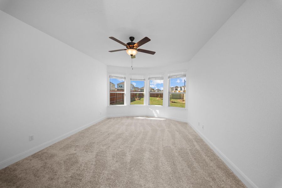 Carpeted empty room with baseboards and ceiling fan Carpeted empty room with baseboards and ceiling fan