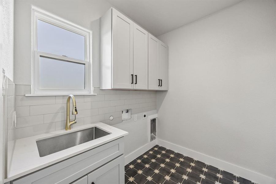 Laundry room featuring dark flooring, cabinet space, electric dryer hookup, and washer hookup