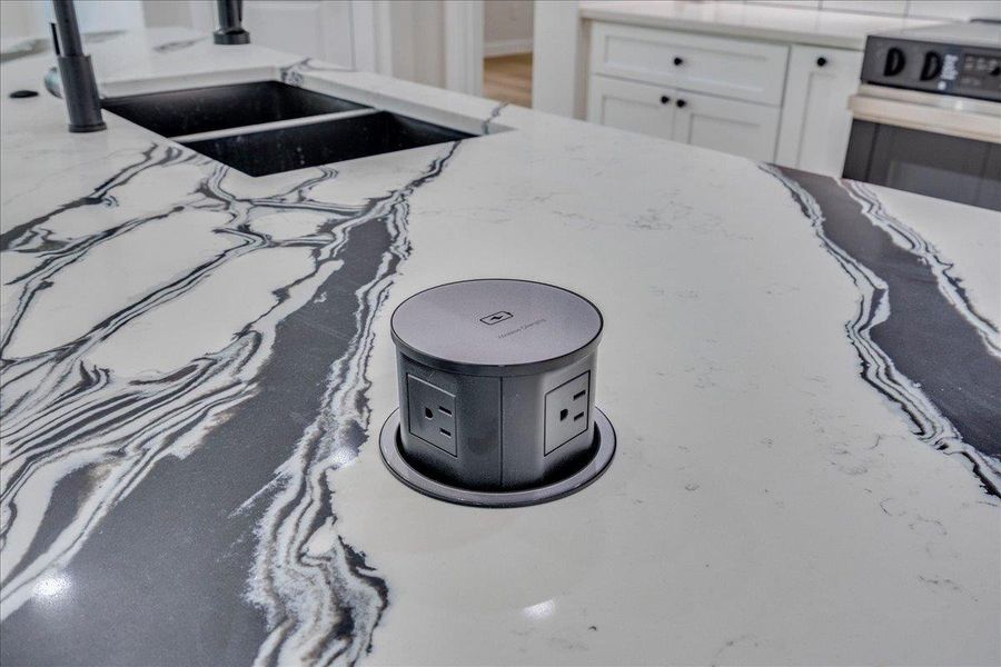 Marble-effect countertops and a hidden power hub that elevates this kitchen island to a functional area
