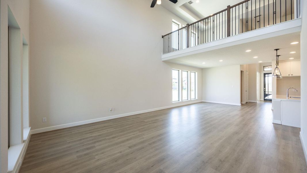 Unfurnished living room with a high ceiling, dark wood-type flooring, and recessed lighting