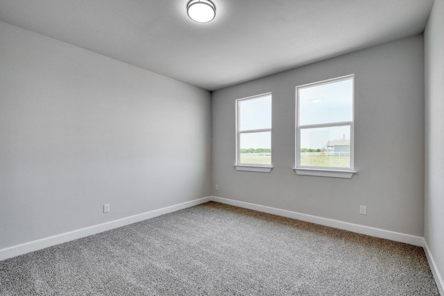 Carpeted spare room with baseboards