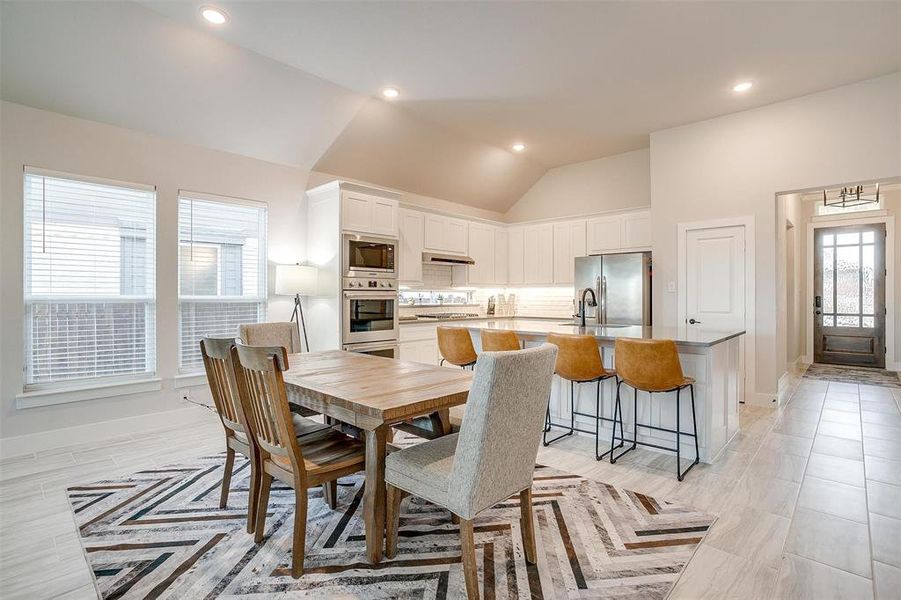 Dining area featuring high vaulted ceiling and plenty of natural light