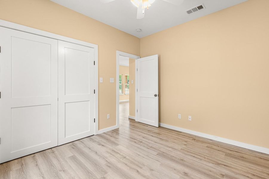 Unfurnished bedroom featuring wood finished floors, a closet, and a ceiling fan