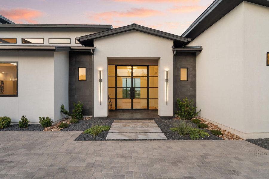 A striking modern facade welcomes with a grand glass entry and thoughtful landscape design.