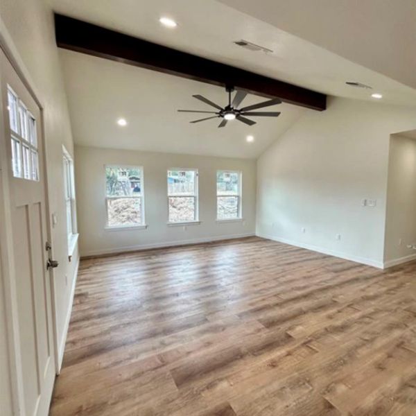 A well-lit interior features high vaulted ceilings and durable wood-look flooring.