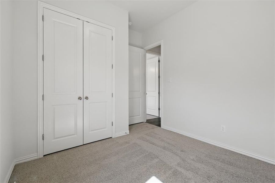 Unfurnished bedroom featuring carpet floors and a closet