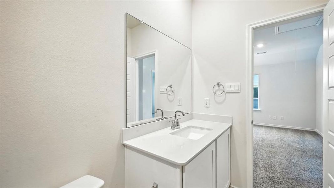 Bathroom featuring carpet flooring and vanity