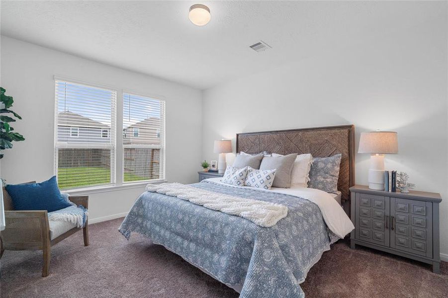 Come and unwind after a long day in this magnificent primary suite! This spacious room features plush carpet, warm paint, high ceilings and large windows with privacy blinds.