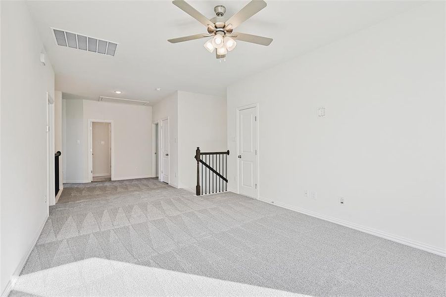 Carpeted empty room with ceiling fan