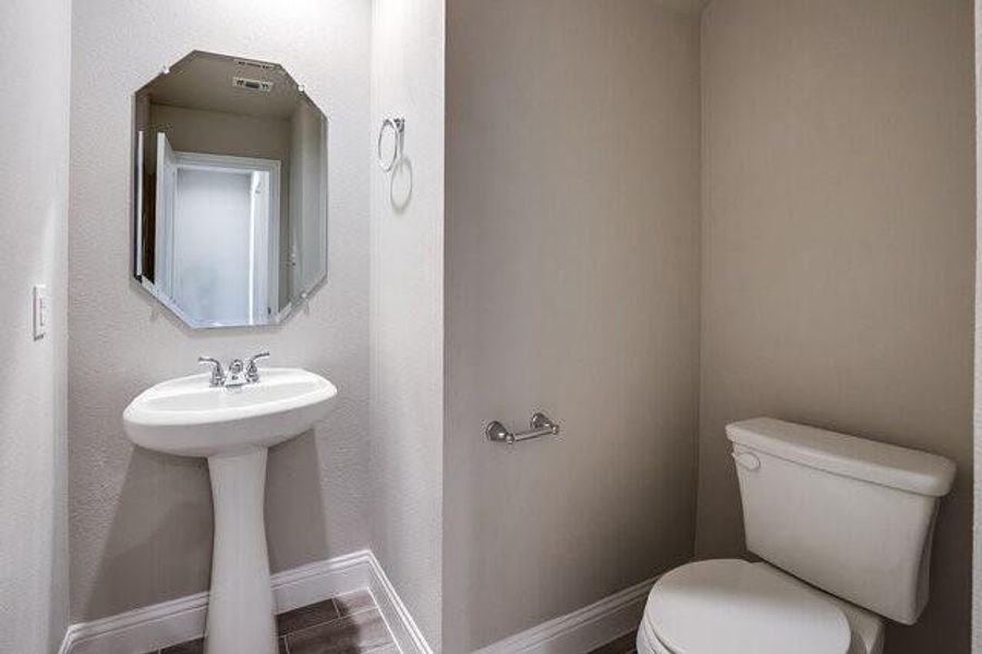 Half bathroom featuring toilet and baseboards