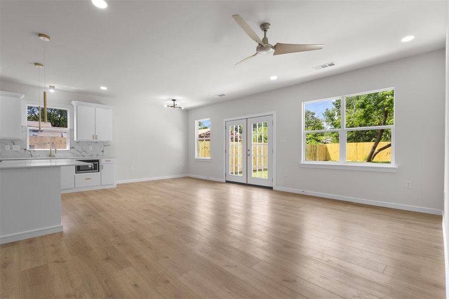 Open-concept living area featuring wood-finish flooring, recessed lighting, and a contemporary ceiling fan