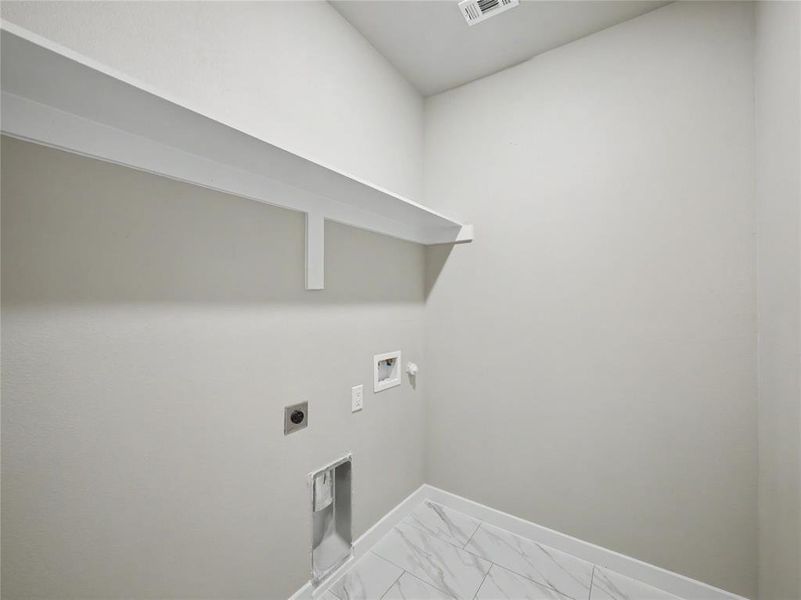 Utility room featuring a white wall shelf, textured white walls, and white baseboards Utility room featuring a white wall shelf, textured white walls, and white baseboards