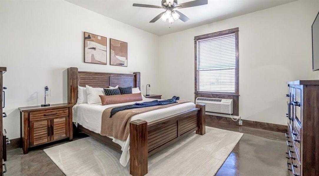 Bedroom featuring finished concrete floors and ceiling fan Bedroom featuring finished concrete floors and ceiling fan