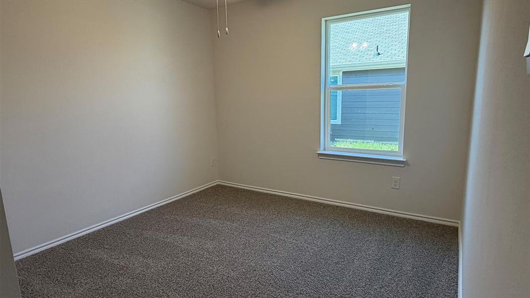 Empty room with dark colored carpet and ceiling fan